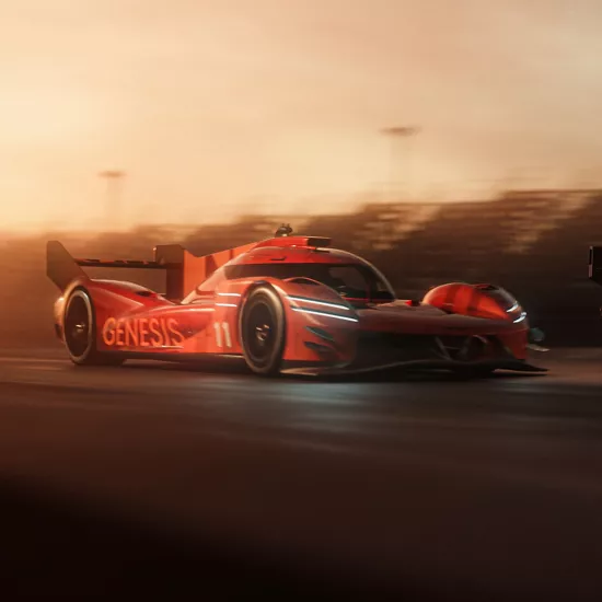 Front passenger side view of the Genesis Magma Racing GMR-001 Hypercar in orange on a race track